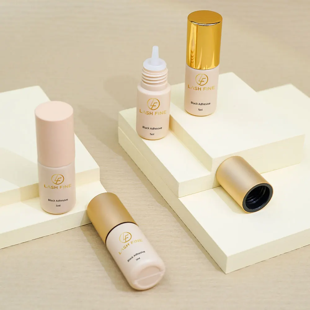 Three lash adhesive bottles with caps on and off on cream display blocks